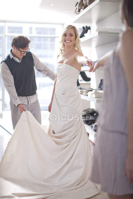 Frau probiert Hochzeitskleid an — Stockfoto