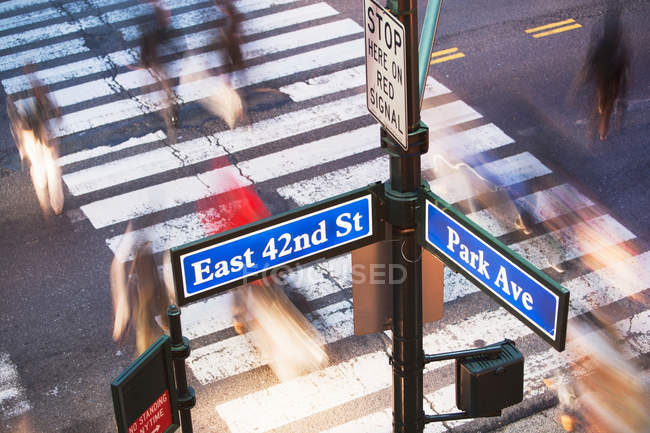 Señal de la calle Park Avenue y peatones borrosos cruzando la carretera Nueva York, Estados Unidos - foto de stock