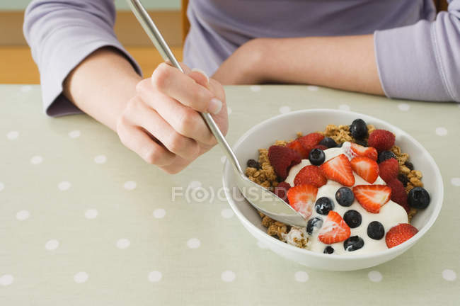 Femme ayant granola petit déjeuner avec des fruits — Photo de stock