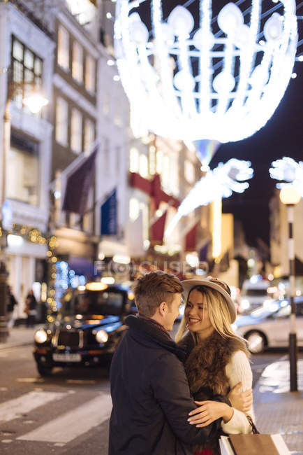 Pareja joven romántica en la calle New Bond en Navidad, Londres, Reino Unido - foto de stock