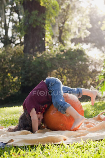 Girl lying on pumpkin — Stock Photo