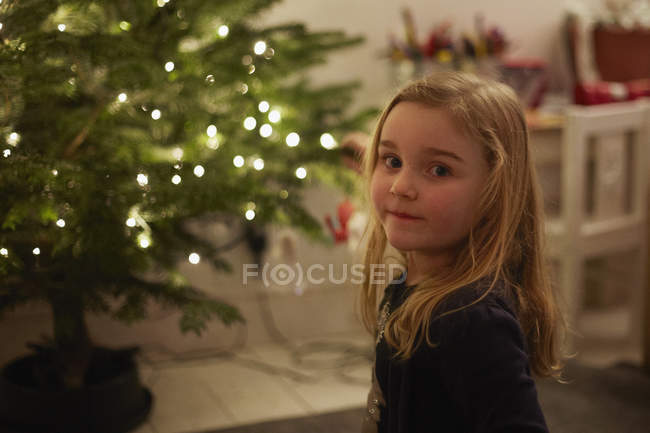 Portrait of young girl and christmas tree — Stock Photo
