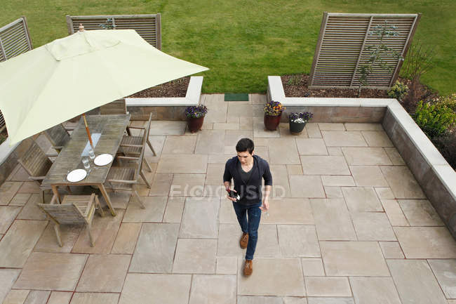 Mann läuft mit Weinflasche über Terrasse — Stockfoto