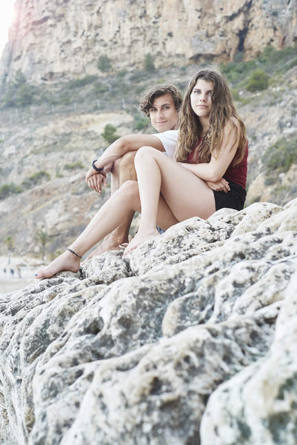 Портрет молодого человека и сестры-подростка на скалистом пляже, Хавея, Испания — стоковое фото