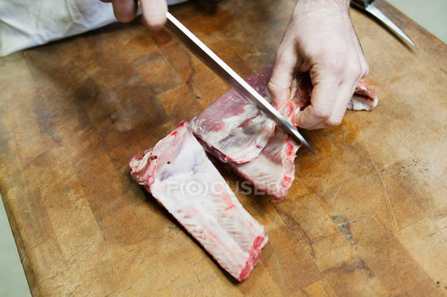Macellaio che prepara costolette di maiale — Foto stock