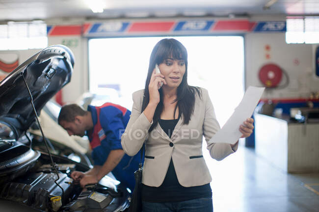 Mulher infeliz leitura documento relativo ao seu carro — Fotografia de Stock