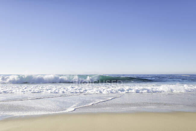 Costa de mar con olas y arena - foto de stock