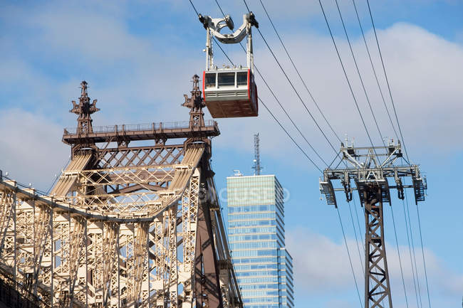 Sessellift über städtische Brücke mit Stadtbild im Hintergrund — Stockfoto