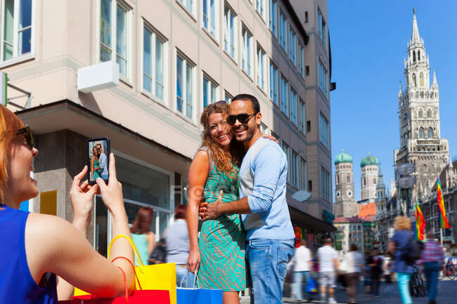Mujer fotografiando pareja en Munich Marienplatz, Munich, Alemania - foto de stock