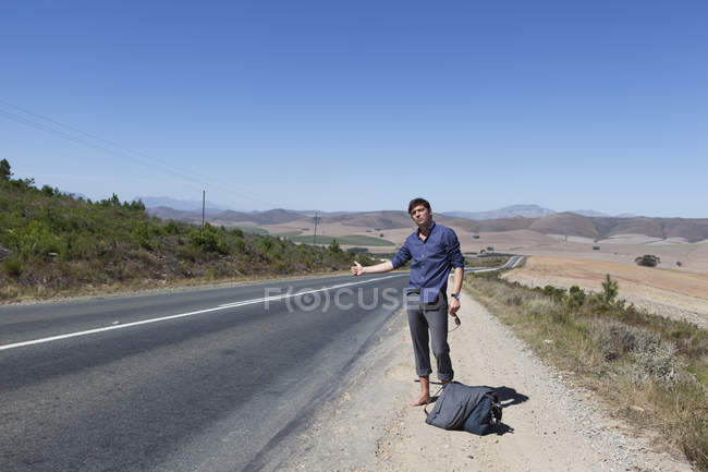 Hitchhiker on side of road — Stock Photo