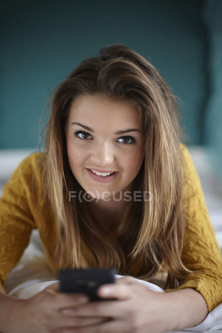 Ritratto di adolescente in camera da letto con smartphone — Foto stock