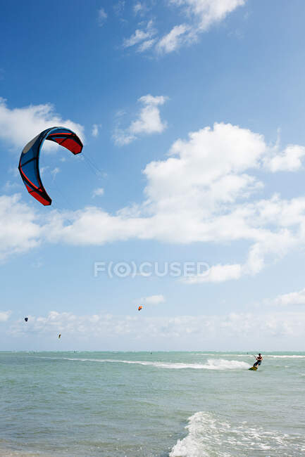 Young man kitesurfing in sea — Stock Photo