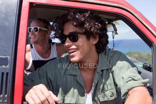 Two men looking out of open car window on vacation — Stock Photo