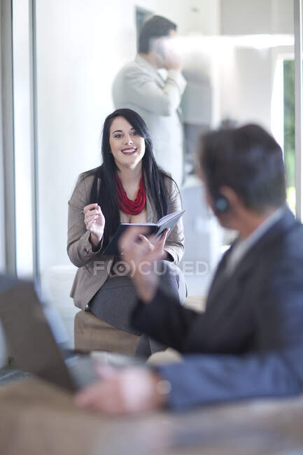 Homme d'affaires utilisant un ordinateur portable, écriture femme d'affaires — Photo de stock