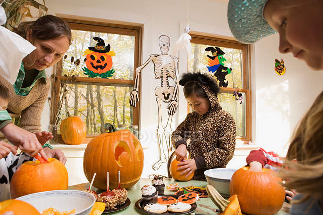 Woman and kids carving pumpkins — Stock Photo