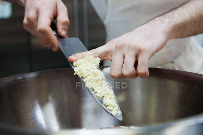 Chef adicionando cebolas em cubos para tigela — Fotografia de Stock