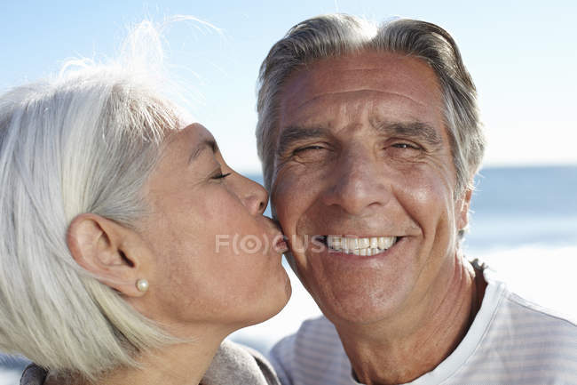 Mulher bicando homem na bochecha — Fotografia de Stock