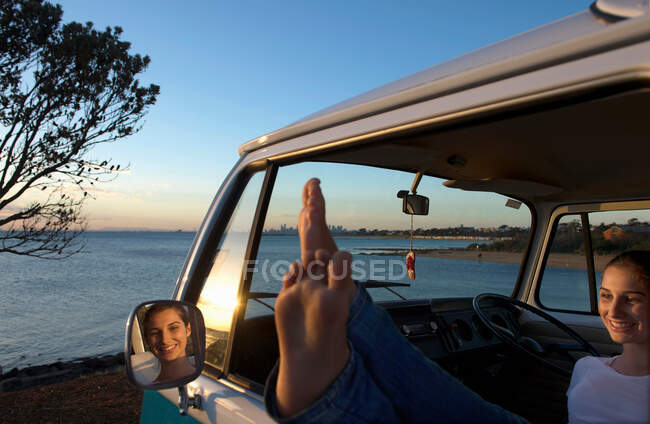 Jeune femme avec les pieds sur la fenêtre du camping-car — Photo de stock