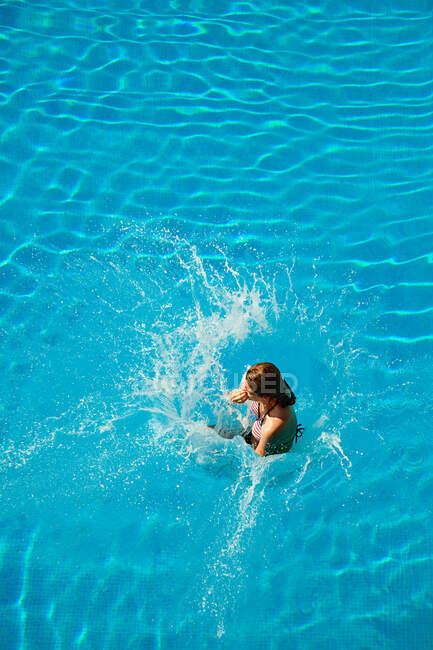 Mujer joven saltando a la piscina - foto de stock