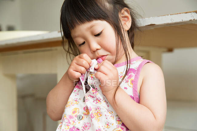 Close up portrait of young girl fastening dress buttons — Stock Photo