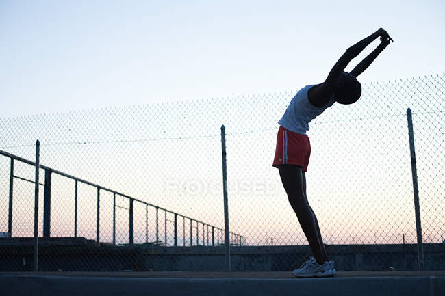 Runner stretching outdoors at the sunrise — Stock Photo