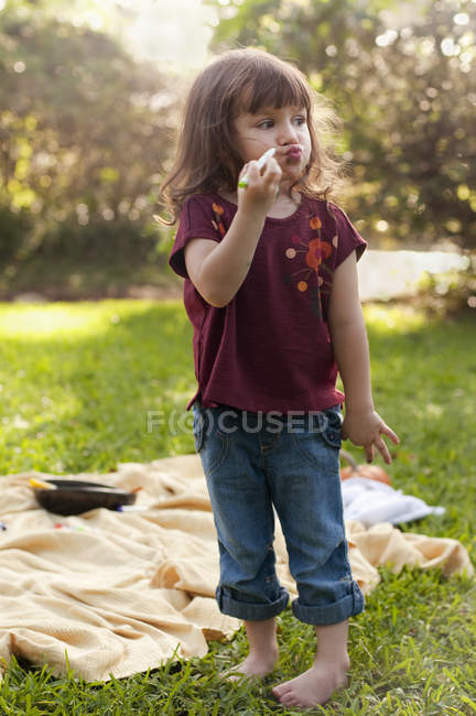Small Girl drawing on face in the park — Stock Photo