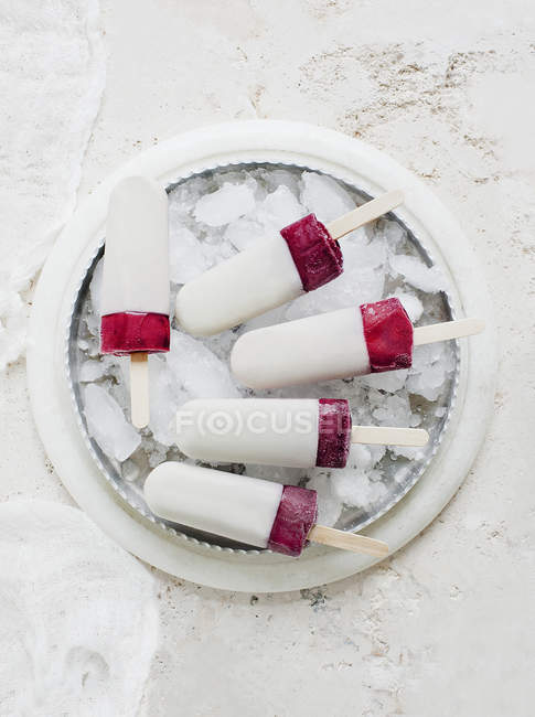Frozen fruit ice lollies dipped in yoghurt — Stock Photo