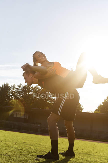 Mujer joven entrenando espalda con espalda con entrenador personal - foto de stock