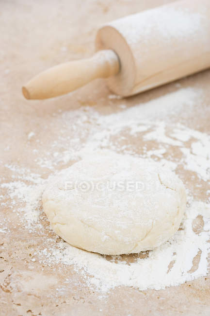 Close-up view of rolling pin and dough — Stock Photo