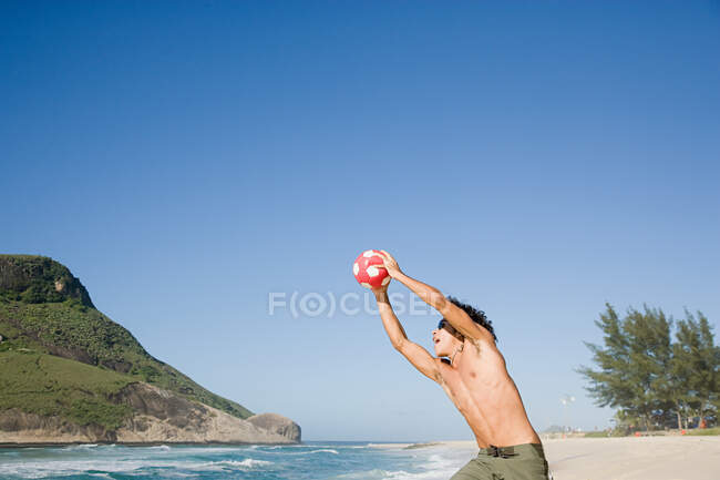 Un adolescente atrapando un balón de fútbol - foto de stock