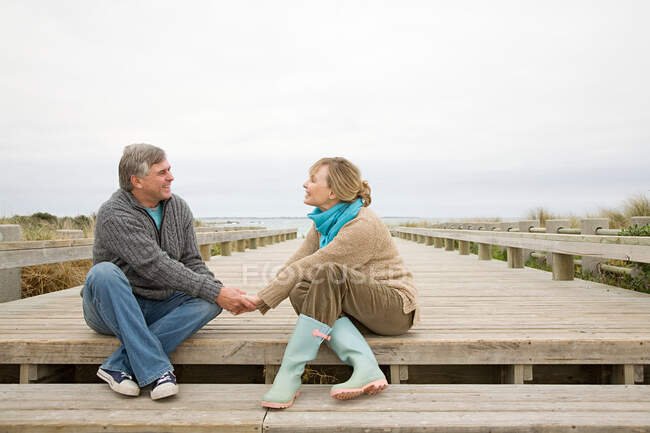 Paar hält Händchen an der Küste — Stockfoto