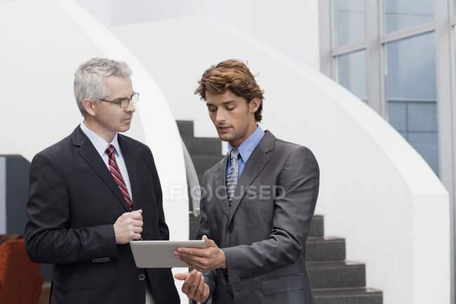 Business colleagues chatting in office atrium — Stock Photo