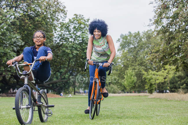 Vista frontal de mãe e filho andando de bicicleta sorrindo — Fotografia de Stock