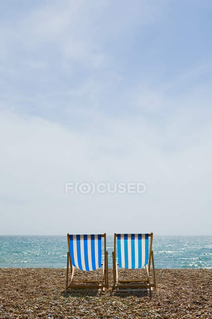 Два порожніх крісла на пляжі на сонячному світлі — стокове фото