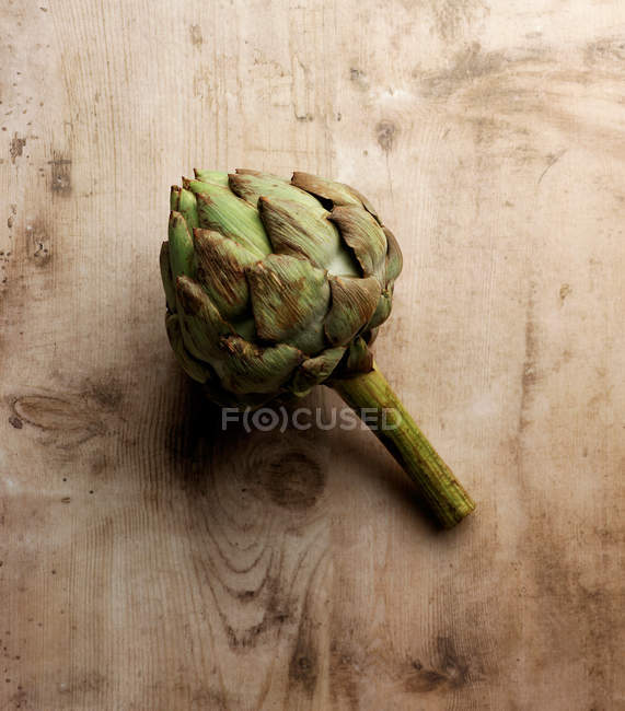 Verdura de alcachofa geren en superficie de madera - foto de stock