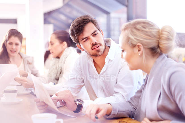 Mujer de negocios y hombre discutiendo el papeleo en la reunión de la oficina - foto de stock