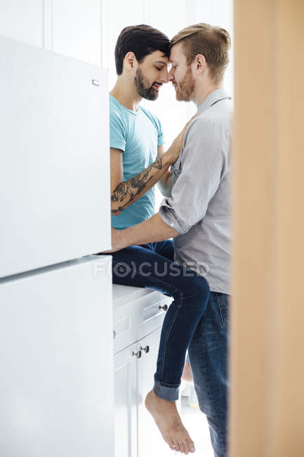 Casal masculino na cozinha, cara a cara, abraçando — Fotografia de Stock