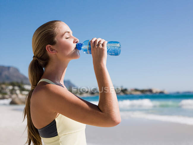 Mujer joven bebiendo agua - foto de stock