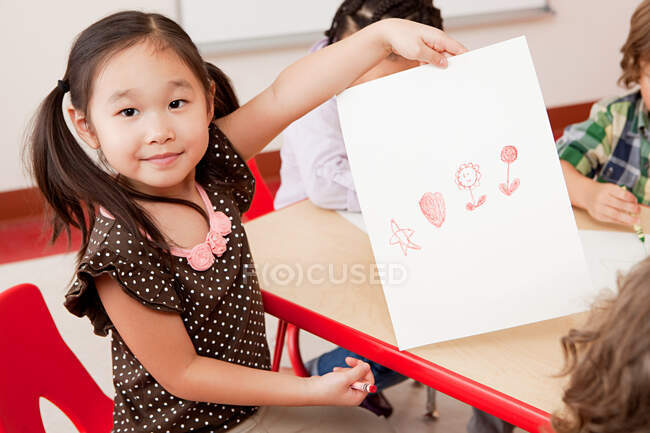 Girl with a crayon drawing — Stock Photo