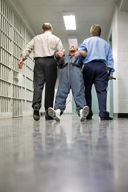Prisioneiro a ser arrastado pelo corredor — Fotografia de Stock