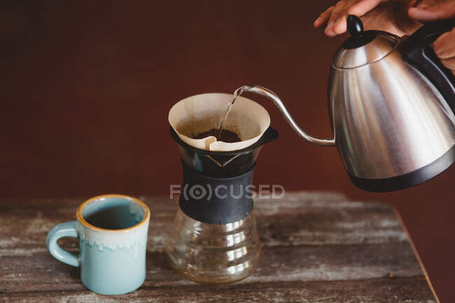 Чоловік вливає воду в фільтр кавоварки — стокове фото