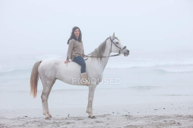 Donna a cavallo sulla spiaggia — Foto stock