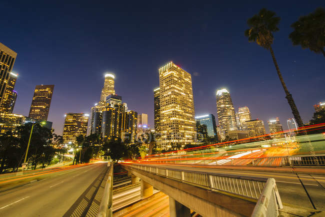 Vista de arranha-céus da cidade e rodovia à noite, Los Angeles, Califórnia, EUA — Fotografia de Stock