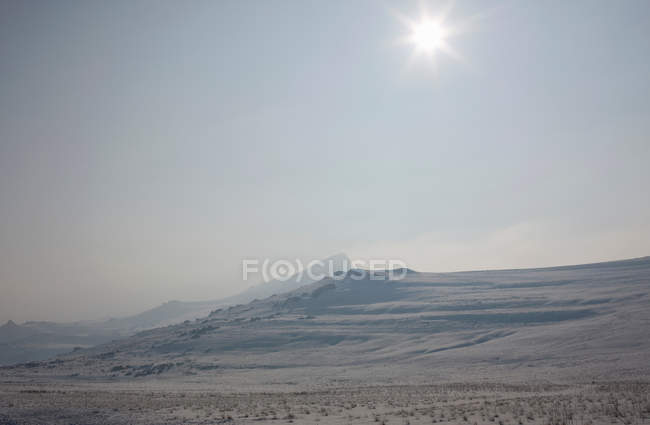 Sonne scheint über verschneite Landschaft — Stockfoto