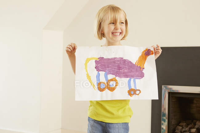 Girl holding up painting of animal — Stock Photo