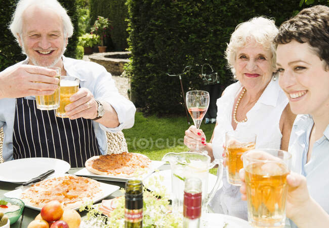 Group of people enjoying food and drink outdoors — Stock Photo