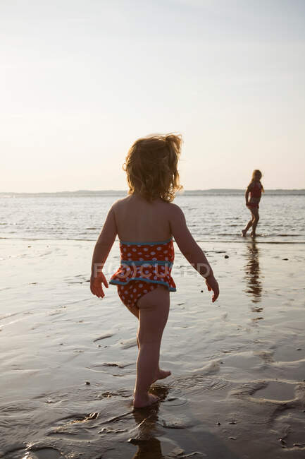 Dos chicas caminando por el mar - foto de stock