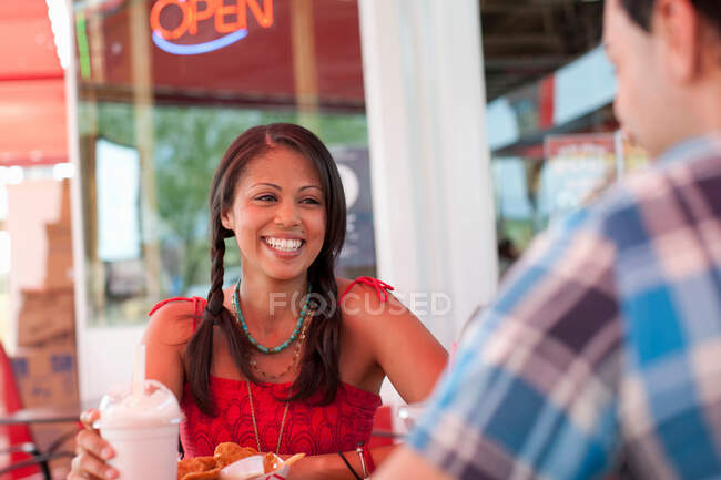 Молода жінка в їдальні, посміхаючись — стокове фото