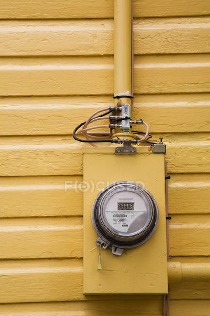 Compteur d'électricité suspendu au mur jaune, vue de face — Photo de stock
