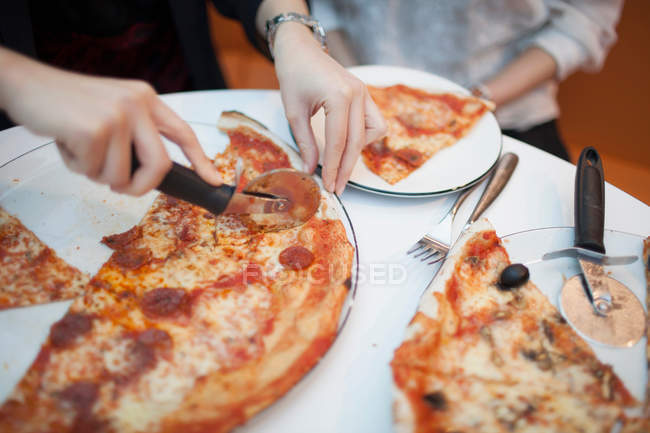 Женщина с помощью резака для пиццы — стоковое фото